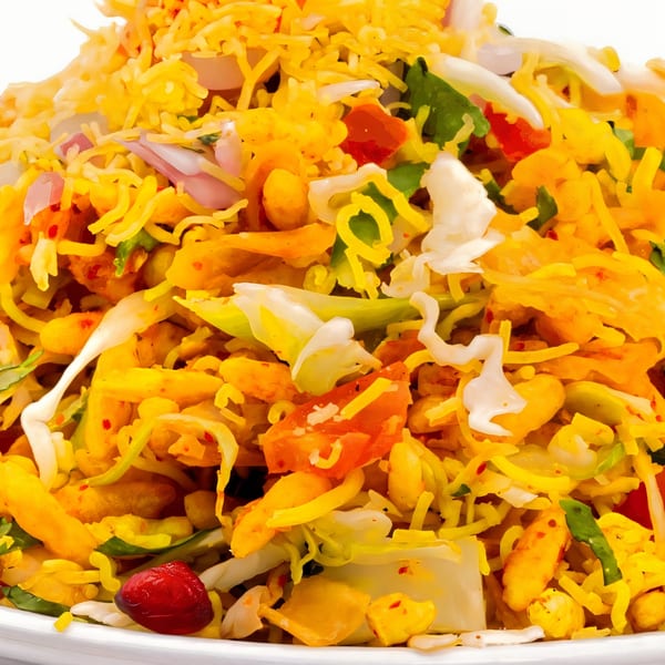 Close-up of a vibrant Indian Bhel Puri dish, with puffed rice, vegetables, and chutneys.