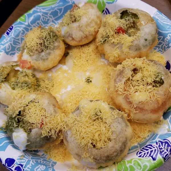 A plate of Mawa House's Indian pani puri, topped with sev and various fillings.
